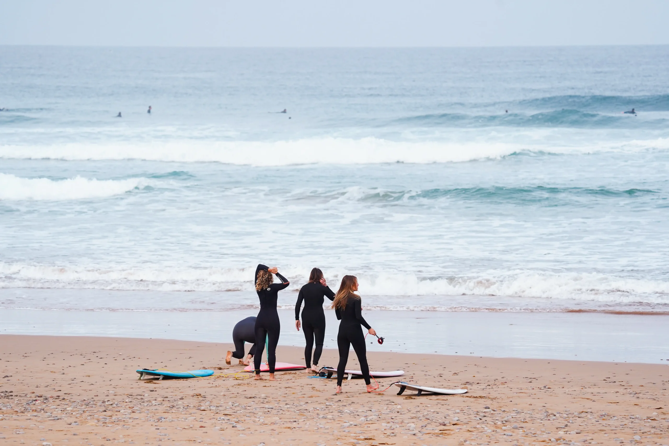 Groupe de surfeurs intermédiaires sur la plage au Maroc, pratiquant le surf.
