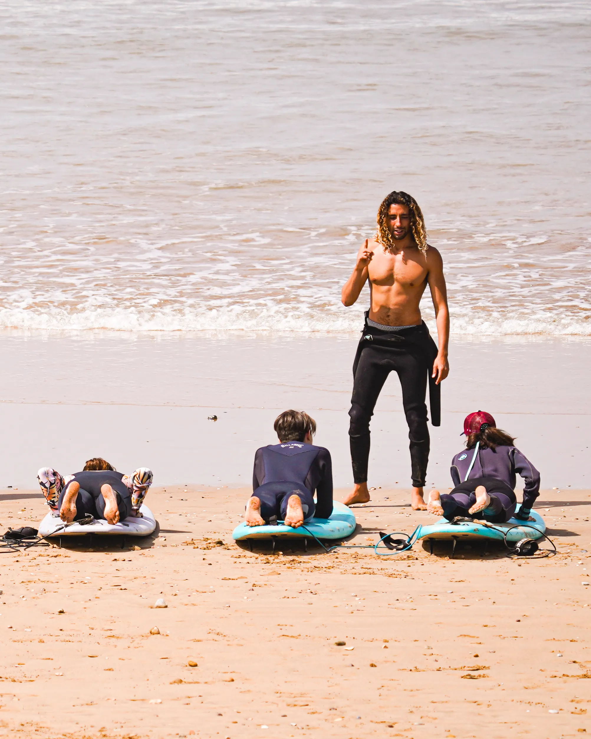 Instructeur de surf enseignant à des débutants sur la plage au Maroc