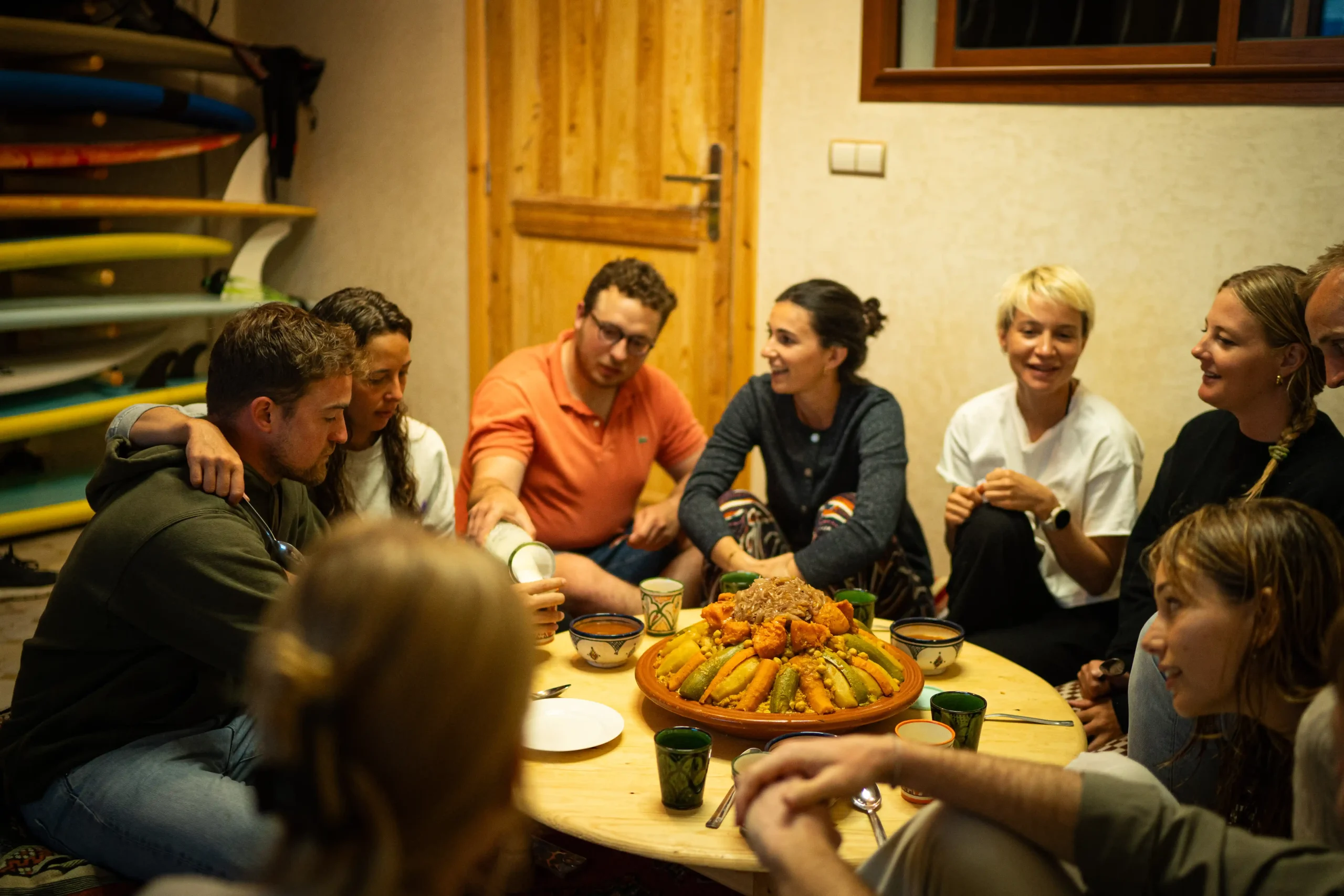 Groupe de surfeurs partageant un repas au surf camp au Maroc.