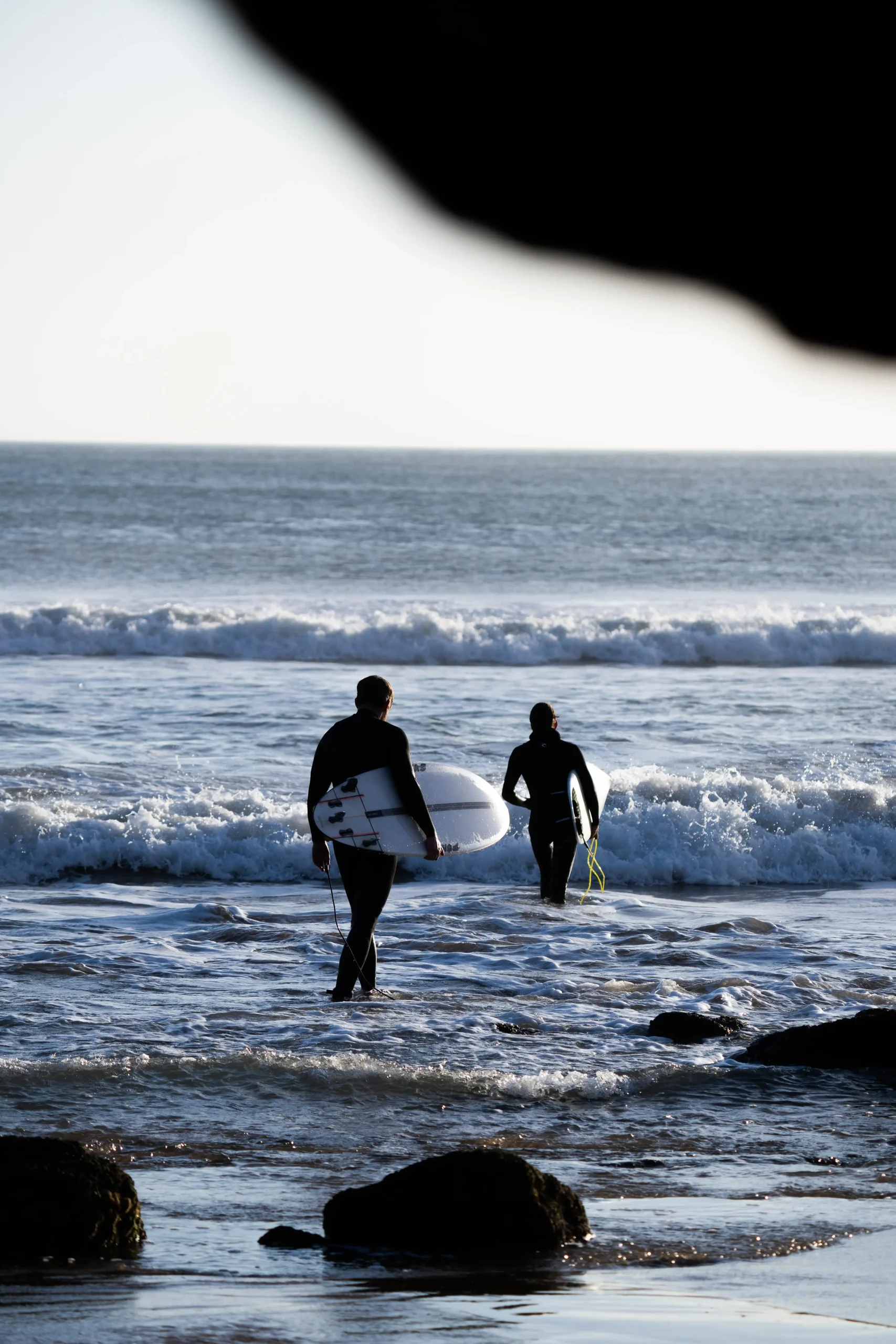 Surfeurs intermédiaires entrant dans l'eau au Maroc pour le surf