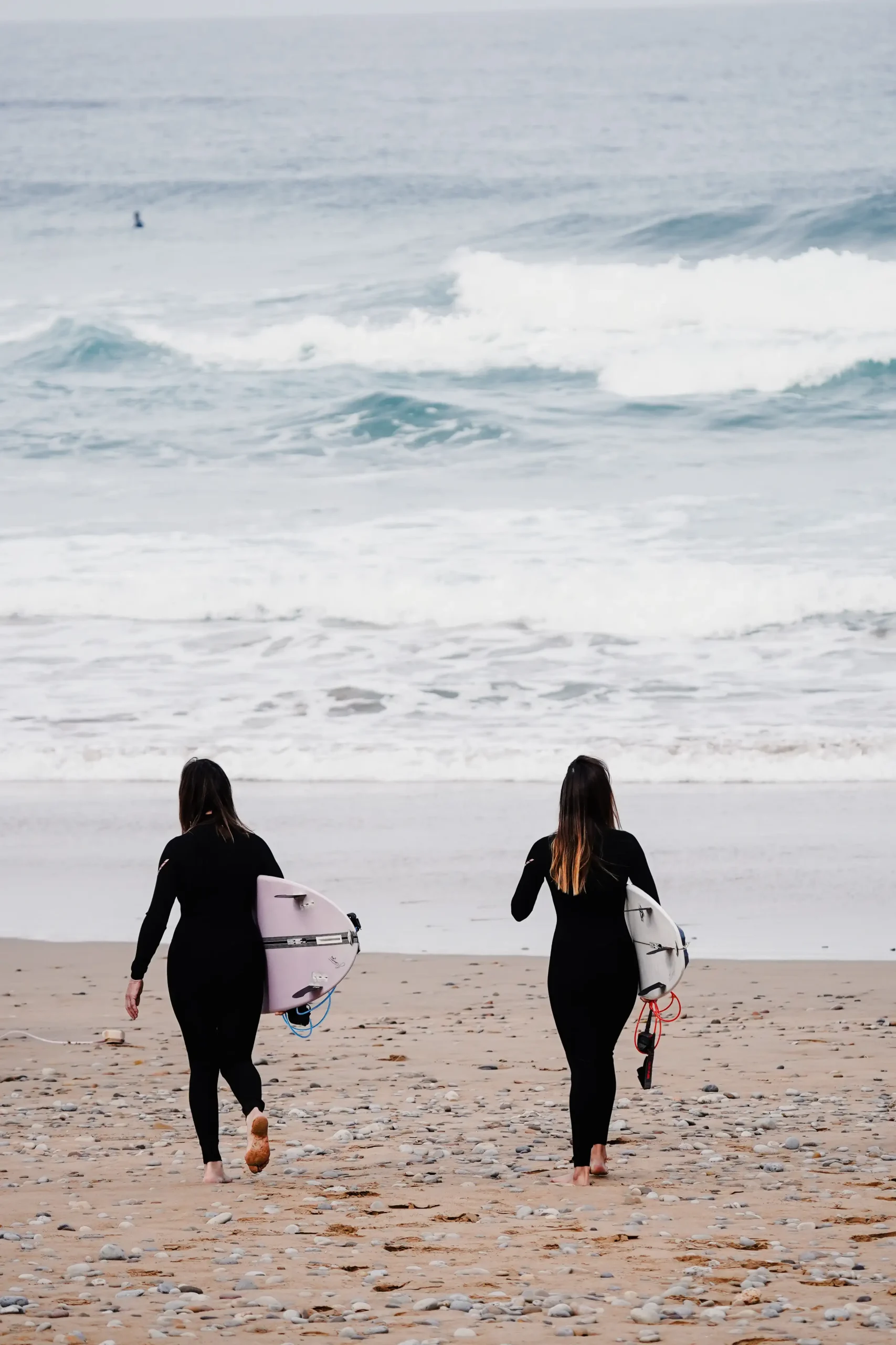 Deux surfeuses se dirigent vers les vagues lors d'un package surf intermédiaire.